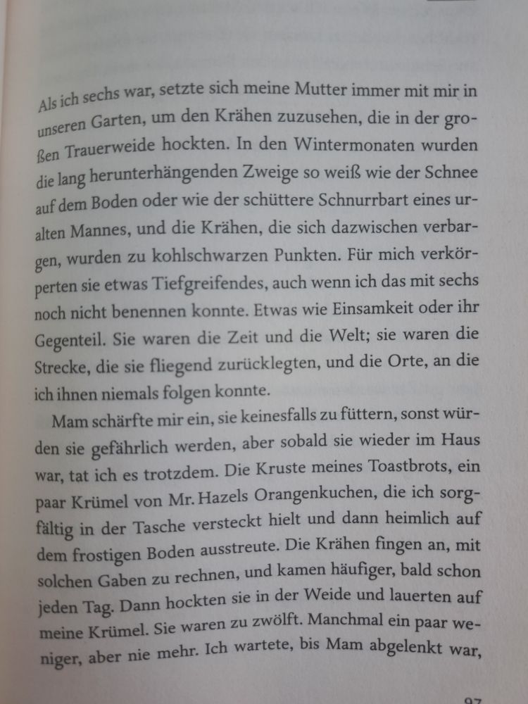 Abforografierte Buchseite:Als ich sechs war, setzte sich meine Mutter immer mit mir in unseren Garten, um den Krähen zuzusehen, die in der gro- Ben Trauerweide hockten. In den Wintermonaten wurden die lang herunterhängenden Zweige so weiß wie der Schnee auf dem Boden oder wie der schüttere Schnurrbart eines ur- alten Mannes, und die Krähen, die sich dazwischen verbar- gen, wurden zu kohlschwarzen Punkten. Für mich verkör- perten sie etwas Tiefgreifendes, auch wenn ich das mit sechs
noch nicht benennen konnte. Etwas wie Einsamkeit oder ihr Gegenteil. Sie waren die Zeit und die Welt; sie waren die Strecke, die sie fliegend zurücklegten, und die Orte, an die ich ihnen niemals folgen konnte.
Mam schärfte mir ein, sie keinesfalls zu füttern, sonst wür- den sie gefährlich werden, aber sobald sie wieder im Haus war, tat ich es trotzdem. Die Kruste meines Toastbrots, ein paar Krümel von Mr. Hazels Orangenkuchen, die ich sorg- fältig in der Tasche versteckt hielt und dann heimlich auf dem frostigen Boden ausstreute. Die Krähen fingen an, mit solchen Gaben zu rechnen, und kamen häufiger, bald schon jeden Tag. Dann hockten sie in der Weide und lauerten auf meine Krümel. Sie waren zu zwölft. Manchmal ein paar we- niger, aber nie mehr. Ich wartete, bis Mam abgelenkt war,