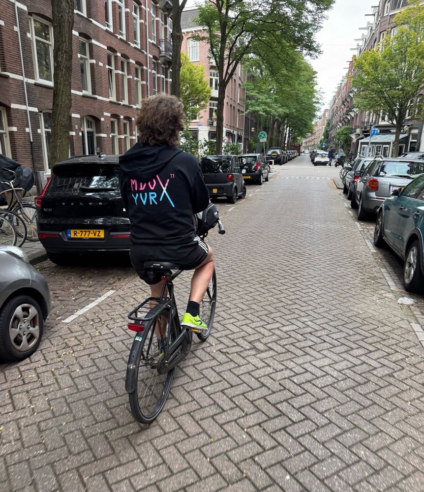 Bike ride on a small road in Amsterdam wearing a MDO YVR conference shirt 