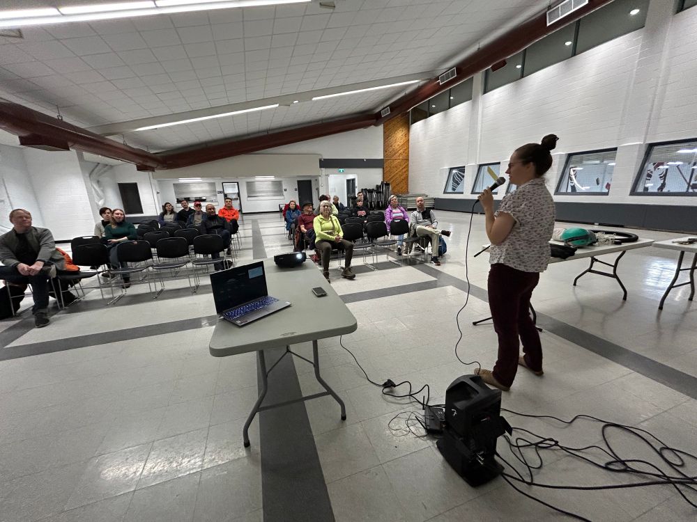 Felicity addresses an audience in a community hall / Félicité s'adresse à un public dans une salle communautaire