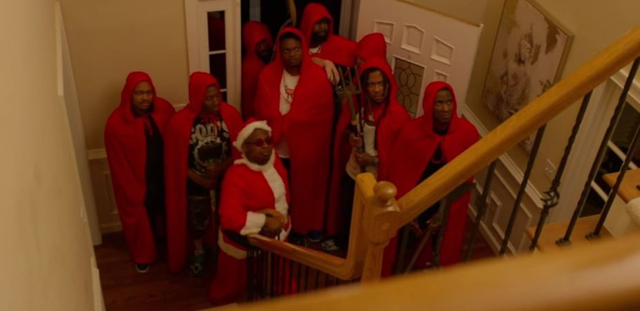 A mob of men in red capes and one in a santa costume