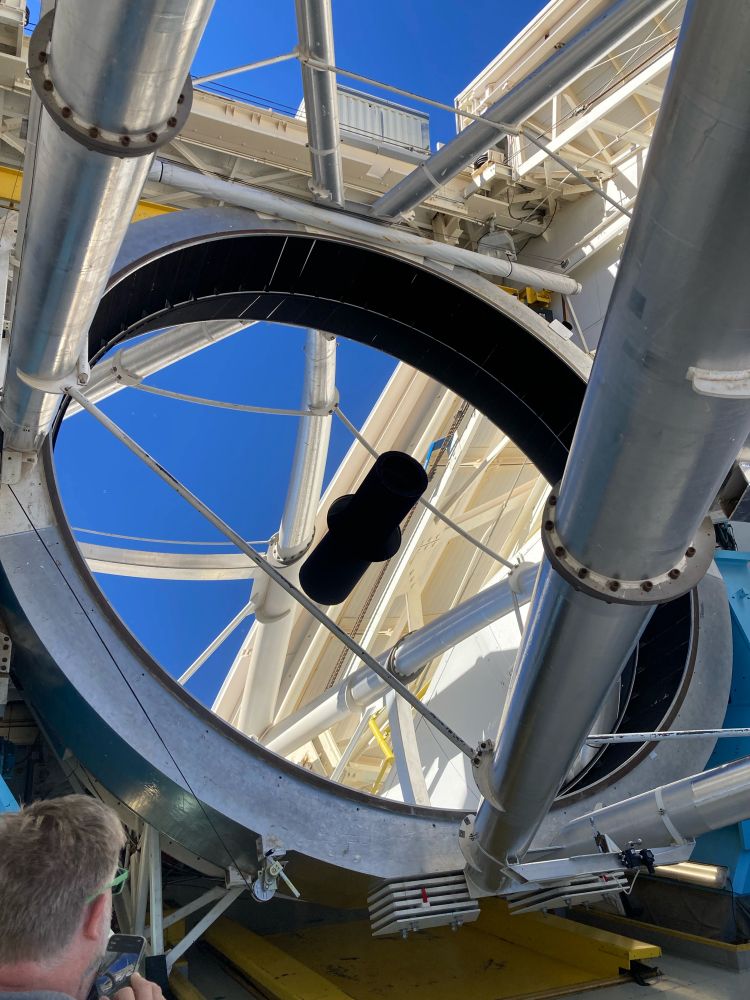 An MMT scientist looking at the reflections in the 6.5 meter telescope mirror