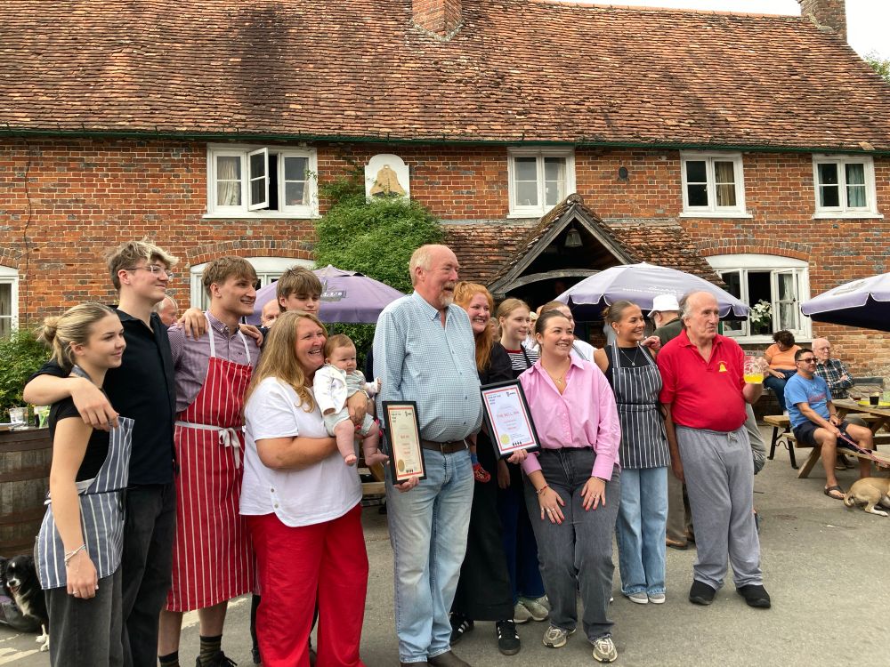 Landlord Hugh, family and staff outside pub. 
