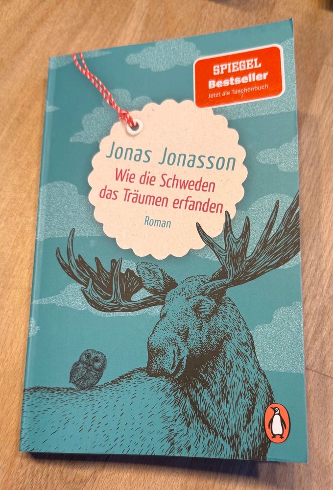Cover des Buchs „Wie die Schweden das Träumen erfanden“ von Jonas Jonasson. Es zeigt einen Elch, auf dessen Rücken eine Eule sitzt. 