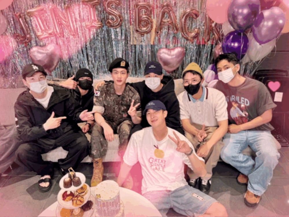 a group of men are posing for a picture with balloons behind them that say it 's back