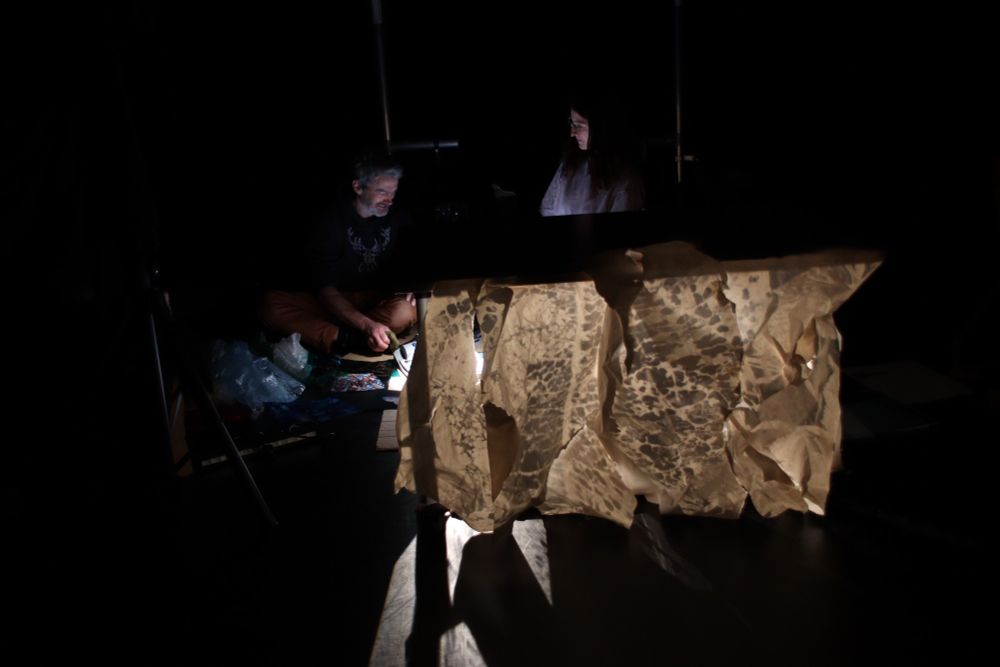 Two of the Hopeful Monster team experiment with light and shadow processes on large printed parchment. 