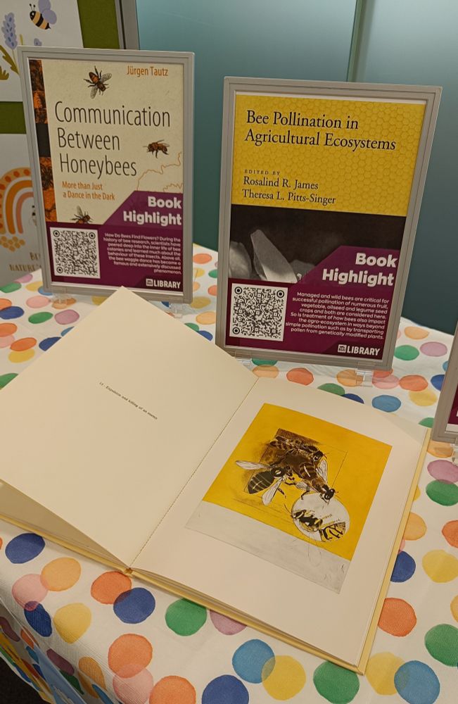 An open book with pictures of bees and 2 posters advertising electronic resources available to our students and staff