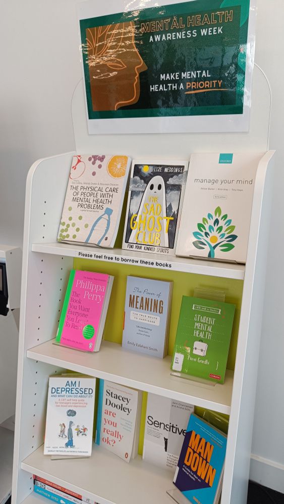 Mental Health Week book display with a poster featuring a head with a healthy tree growing in it