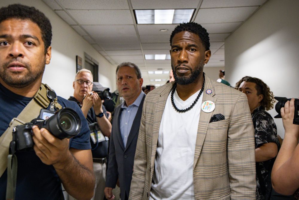 The Public Advocate and Comptroller in the hallway of 26 Federal Plaza, with concerned expressions, as reporters look on