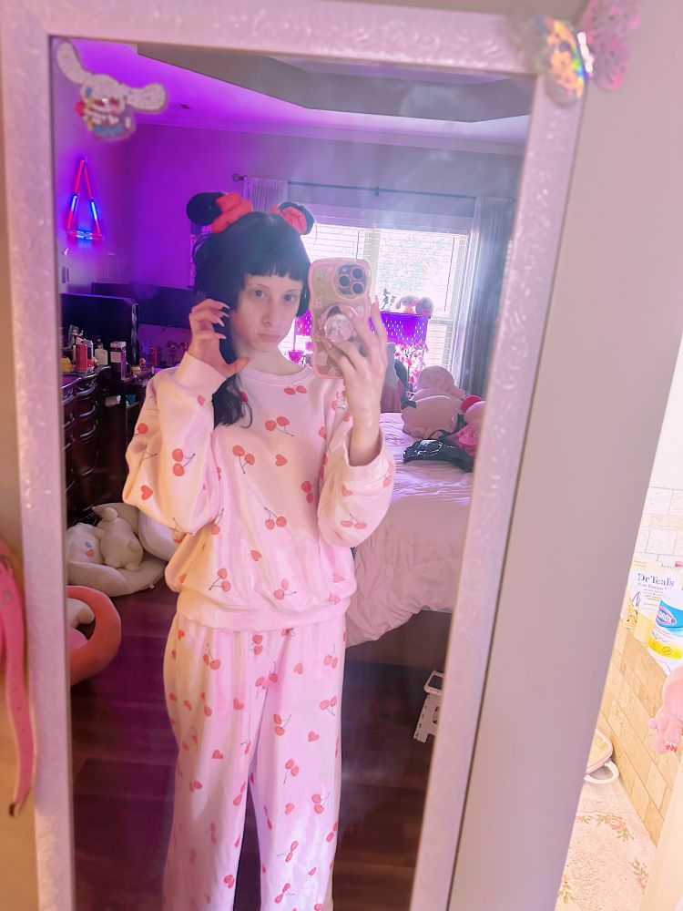 mirror selfie of bunny in a cherry print pajama set in her room