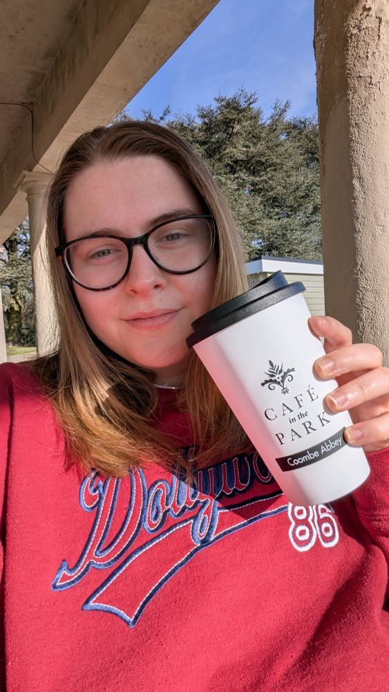 Charlotte smiles as she enjoys her post-run oat flat white from the local cafe