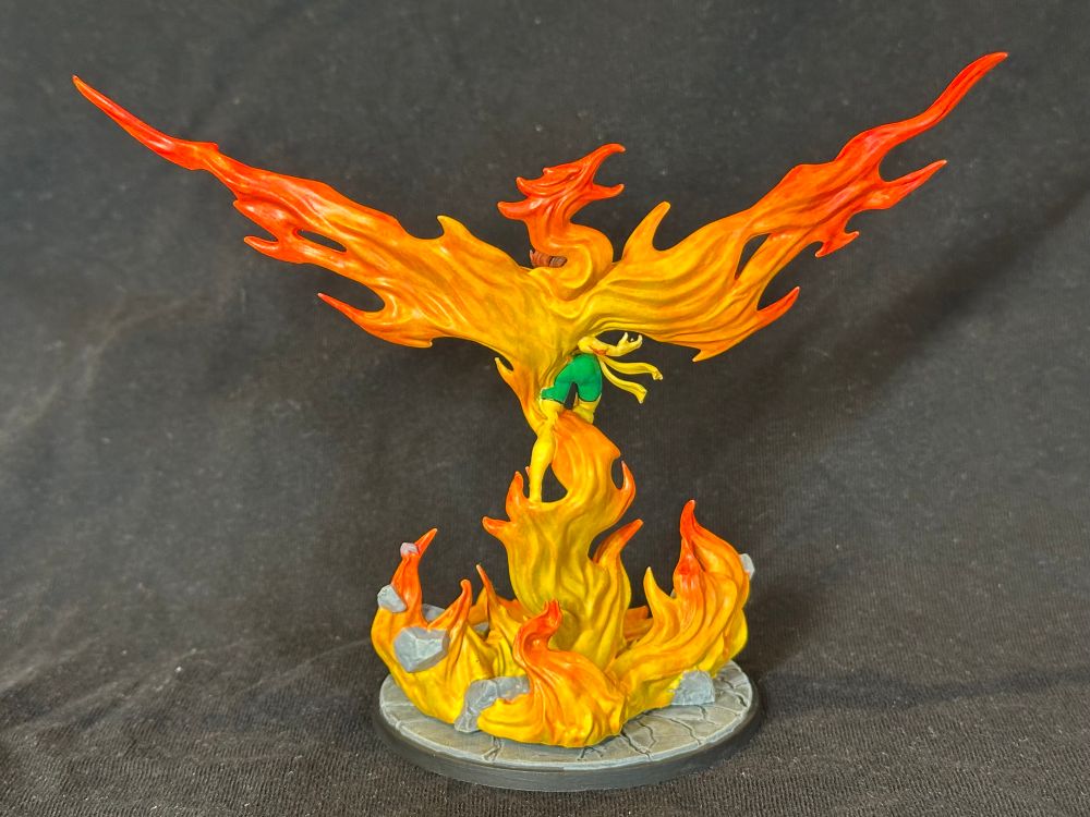 Phoenix Unleashed model from MCP viewed from the rear. A woman in green and yellow rising out of a fire in the shape of a bird
