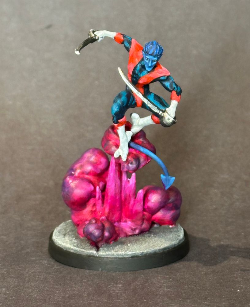 Nightcrawler model from Marvel crisis protocol. Blue skinned man with two swords jumping out of magenta smoke