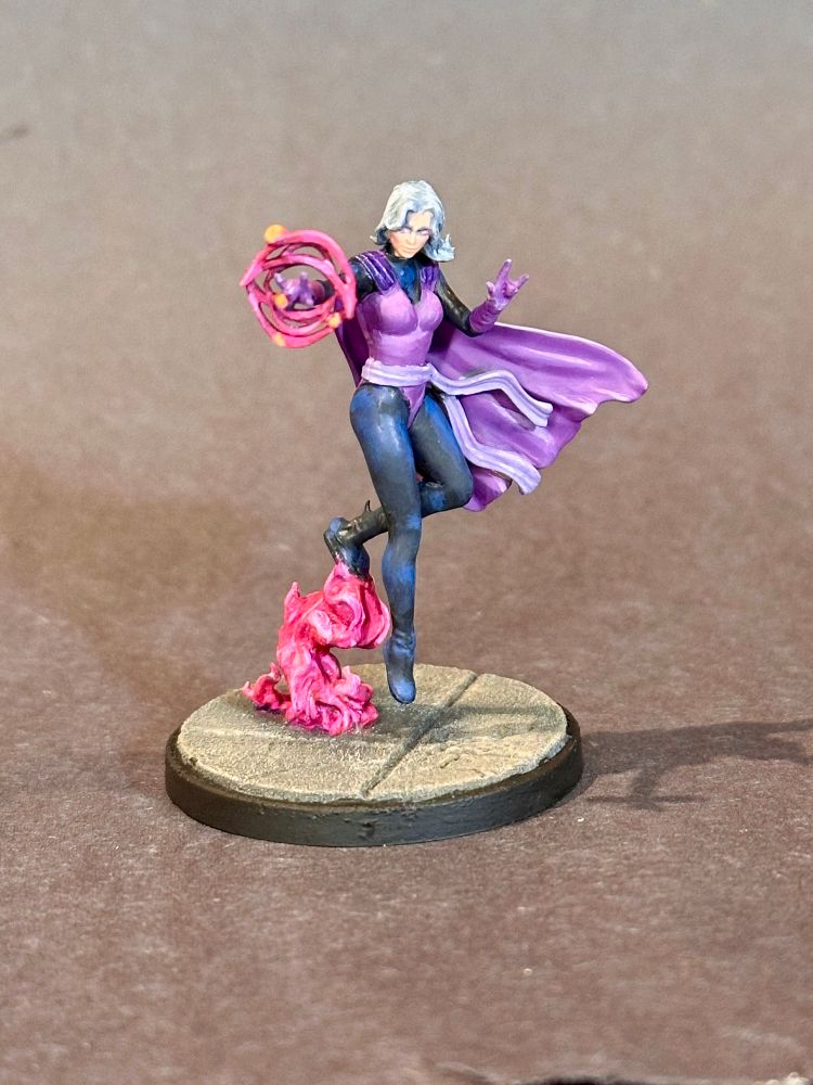 Painted Clea model from Marvel Crisis Protocol
A woman wearing a purple jumpsuit with a purple cape, hovering over some magenta fire, doing song magic