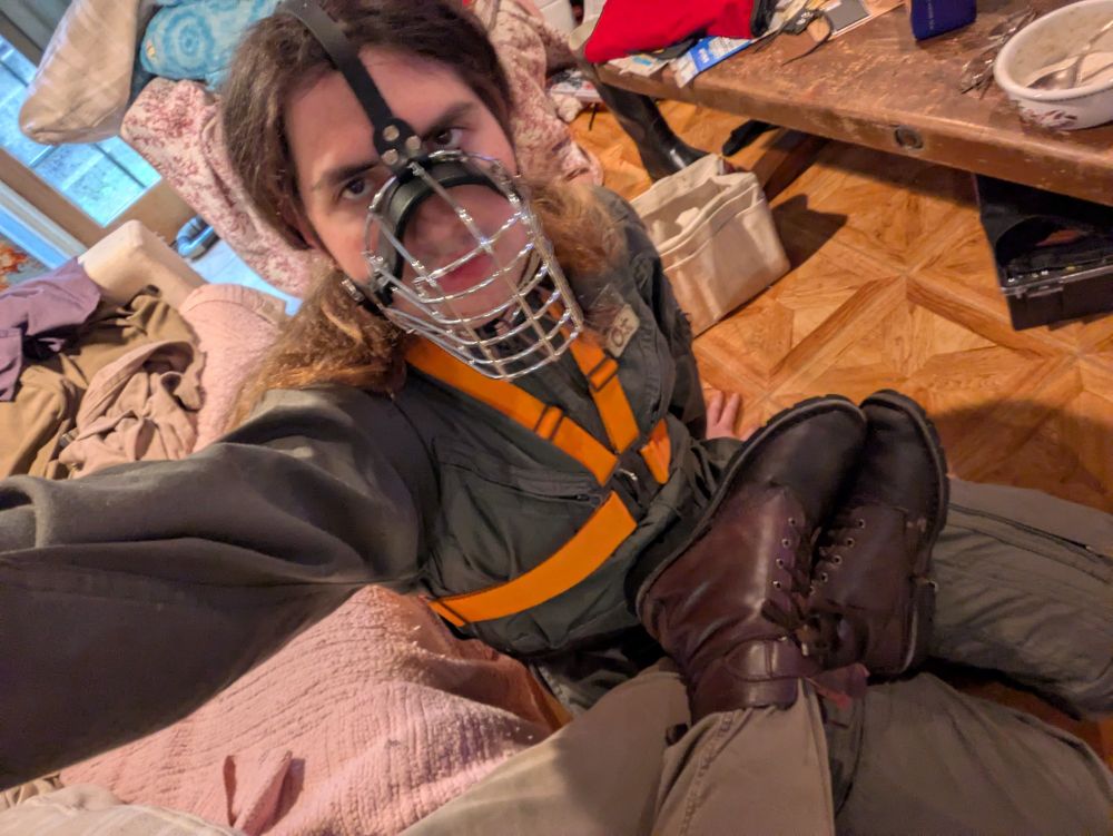 Yours truly in the flight suit, harness, and muzzle, with bo's boots on my lap
