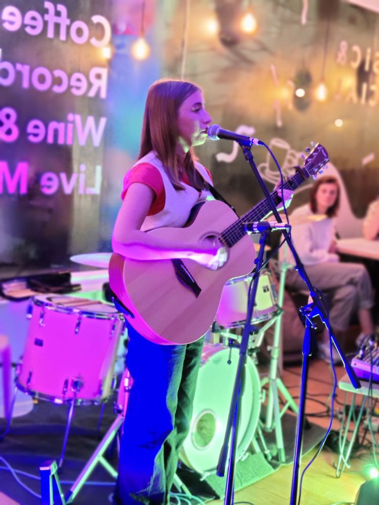 Kitty Crocker performing live on acoustic guitar