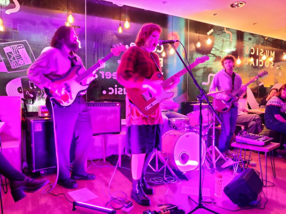 Moya Silk performing live, bathed in pink light