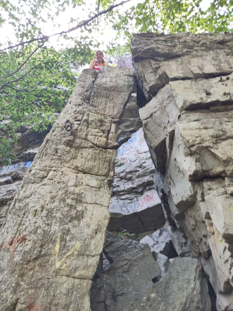 Climber on top of a large rock going straight up