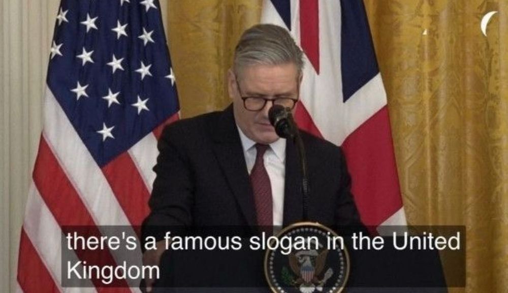 Kier Starmer in front of a microphone with the UK and US flags behind him saying "there's a famous slogan in the United Kingdom"