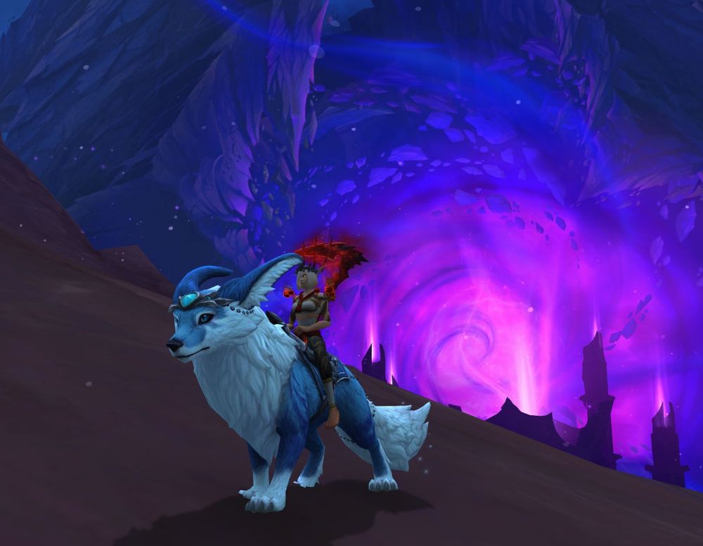 A blood elf Monk riding the Vulpine Familiar mount, standing on a rock with the ruined world K'aresh looming in the background.