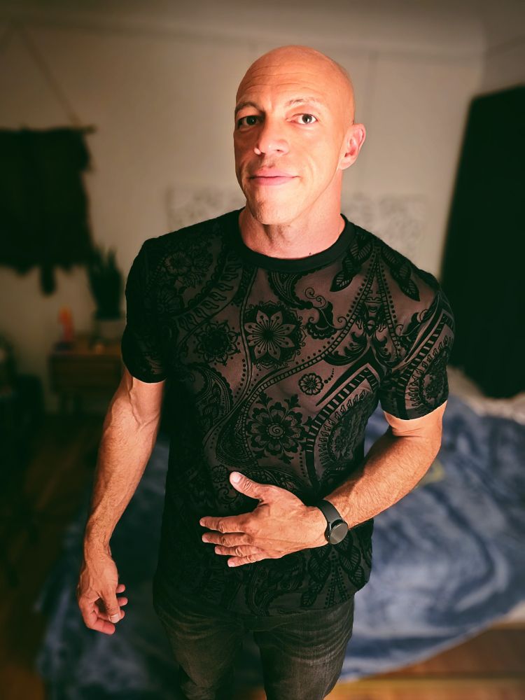Rob Denali poses in a black top