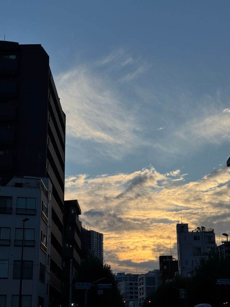 建物の奥に見える朝焼けと雲