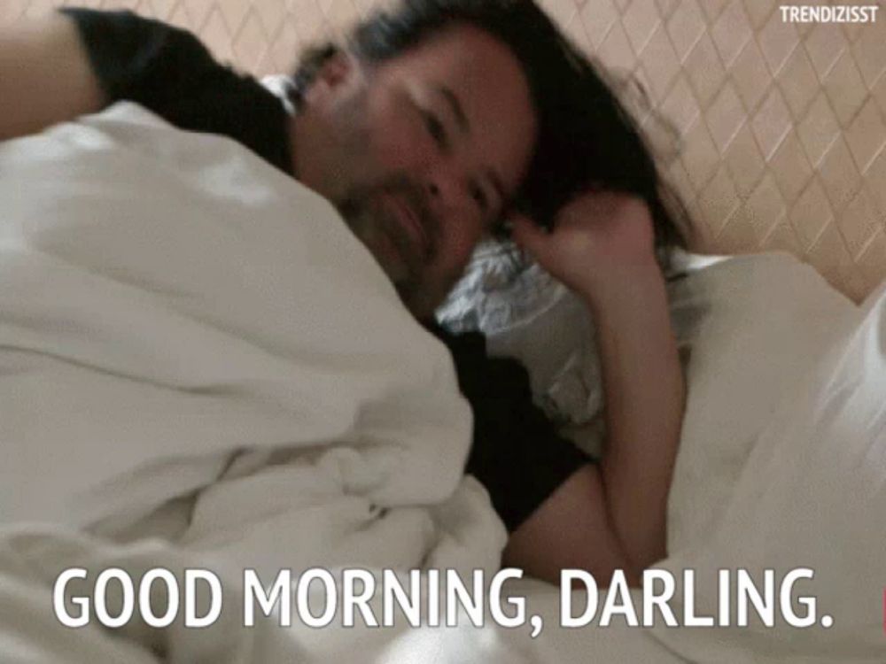 a man is laying in bed with the words " good morning darling " on the bottom