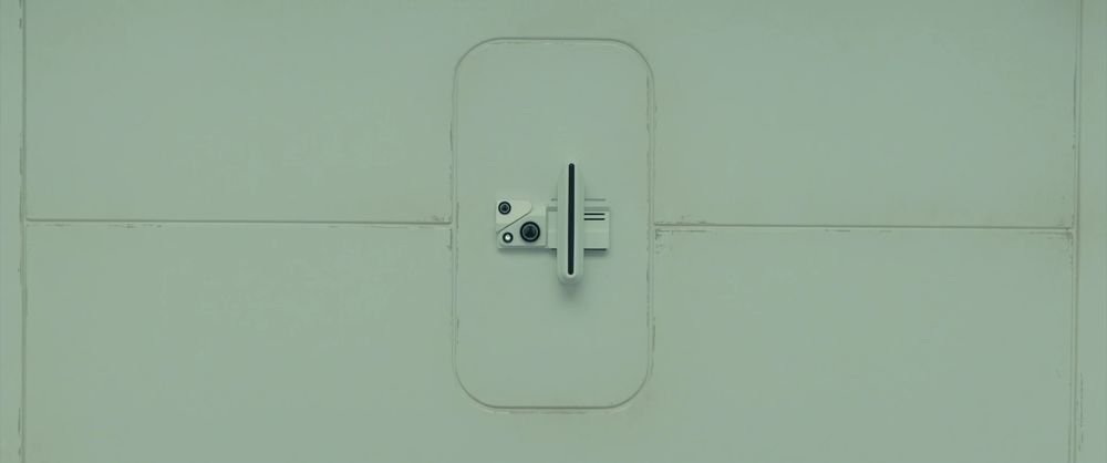 The 'baseline' test from Blade Runner. A series of cameras and scanners, center screen, in the middle of an impersonal white-paneled wall. 