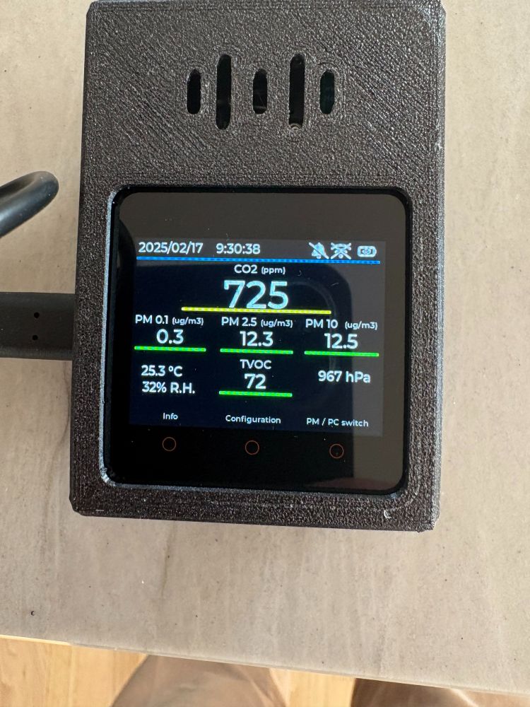 The picture showes an Air Particulate Monitor with Air Qaulity levels from an indoor setting. CO2 levels aT 725 PPM: pm 0,1 at 0,3 and PM 2,5 at 12,3