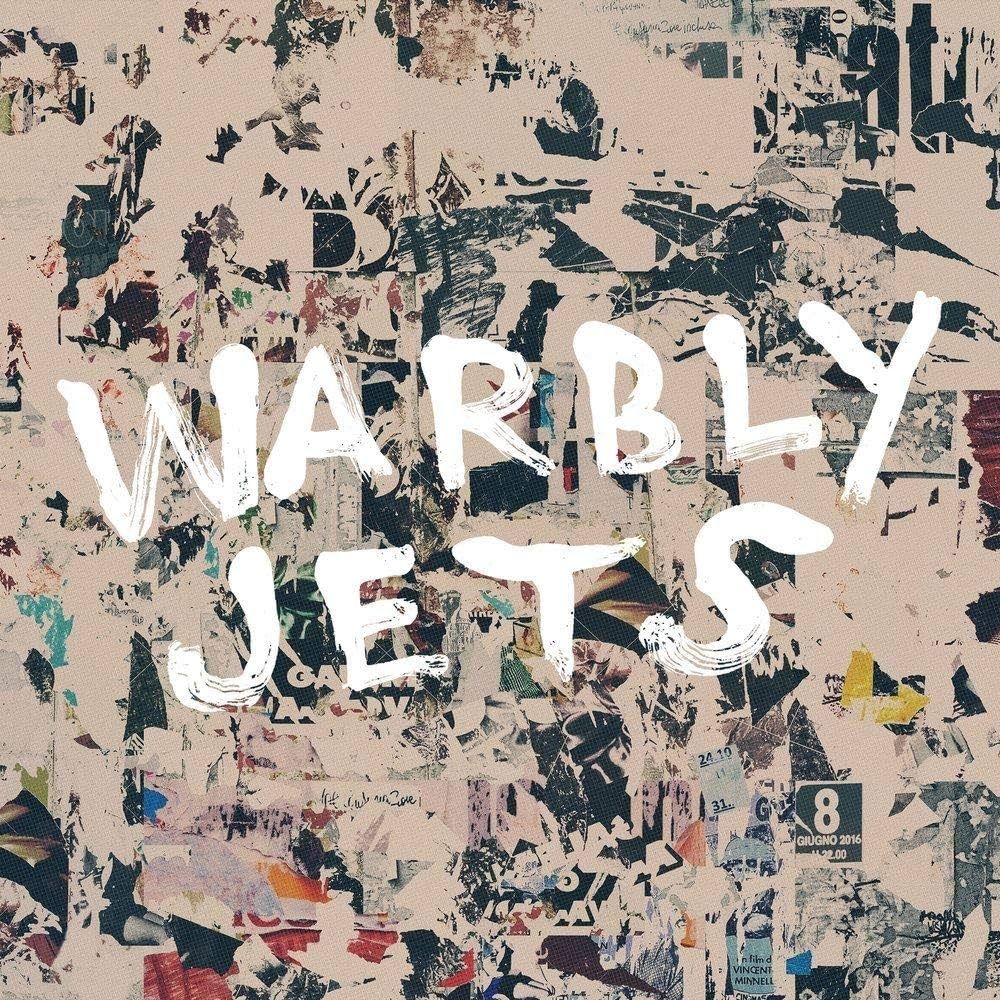 Cover art for Warbly Jets' first album: a beige background with scattered/scratched stickers and the name Warbly Jets painted in white over the top