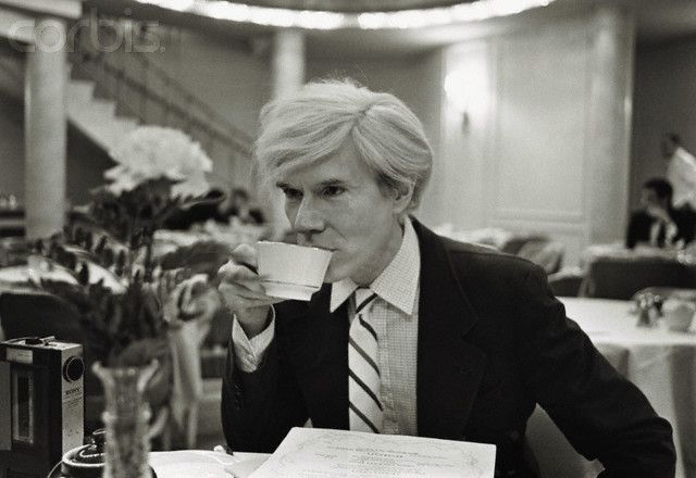 black and white photo of Andy Warhol sipping coffee