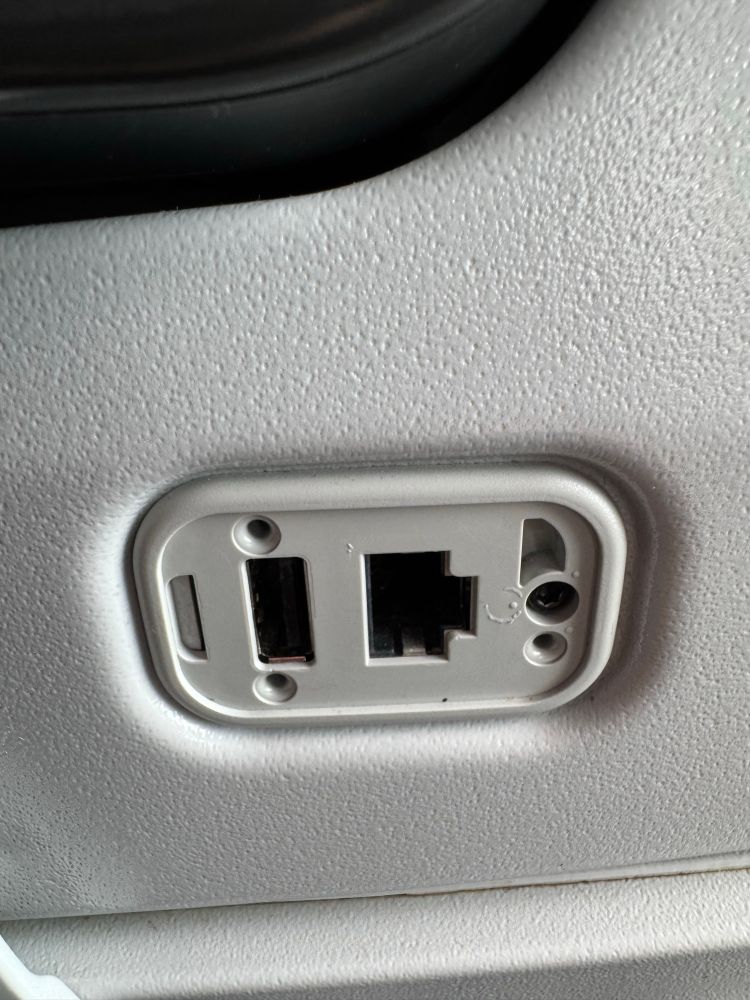 Closeup of an airplane seat with USB-A and Ethernet on the back