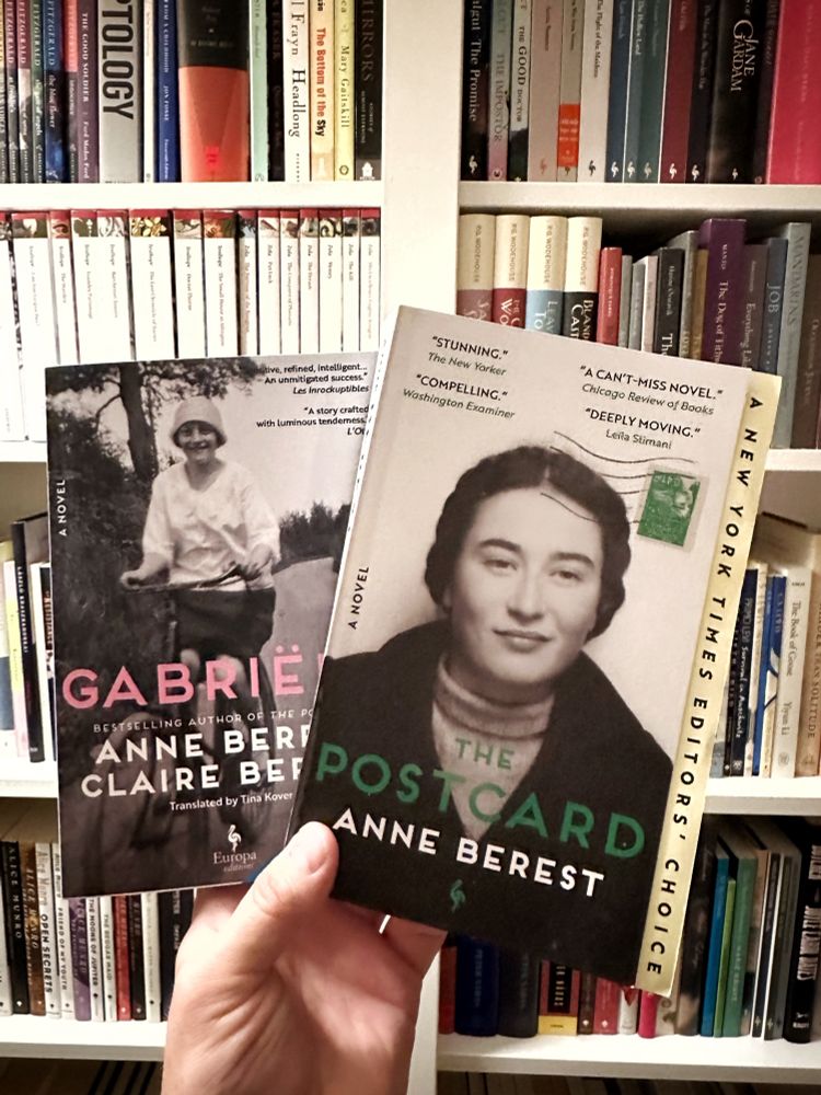Holding two books in front of my shelves: Anne Berest’s The Postcard and Anne Berest and Claire Berest’s Gabriële. 