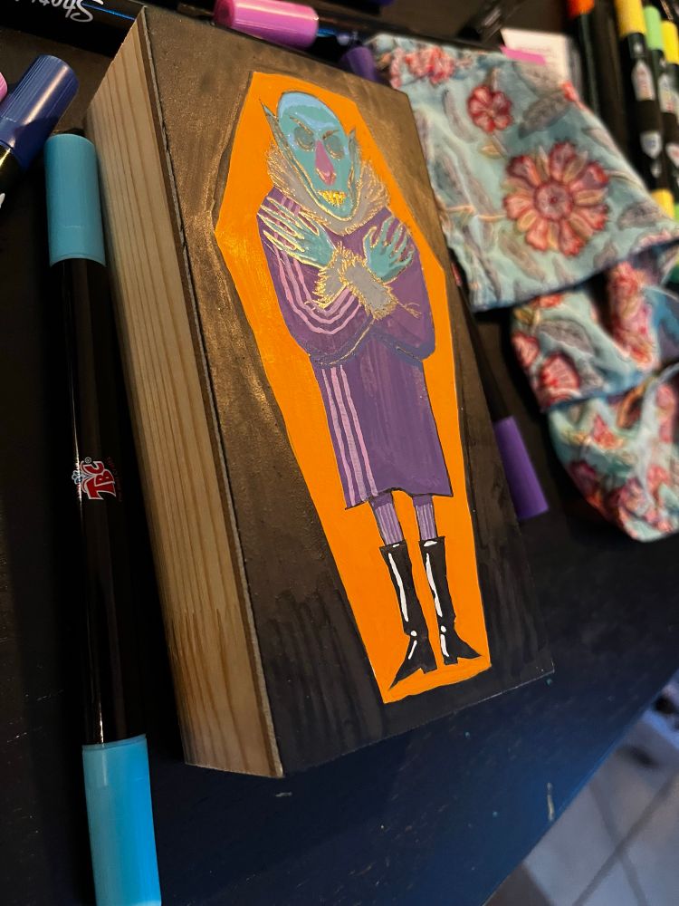 A side view of an illustration of a stylish vampire sleeping in a coffin.