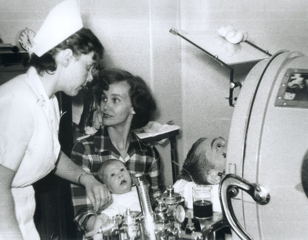Man in iron lung being visited by his family