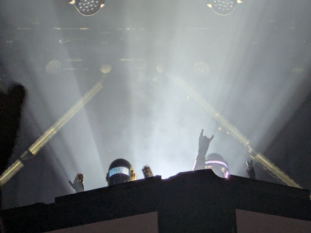 A photo of a Daft Funk Tribute concert where you can see Daft punk on top of a visual set. (They are not the actual band, just actors)