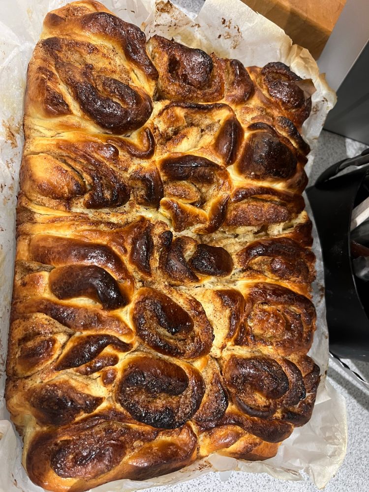 Roasting tin of cinnamon buns with crusty bits, all merged into one delicious bake for sharing 