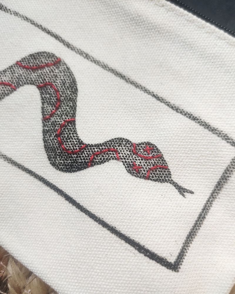 Gros plan des motifs brodés sur le serpent.