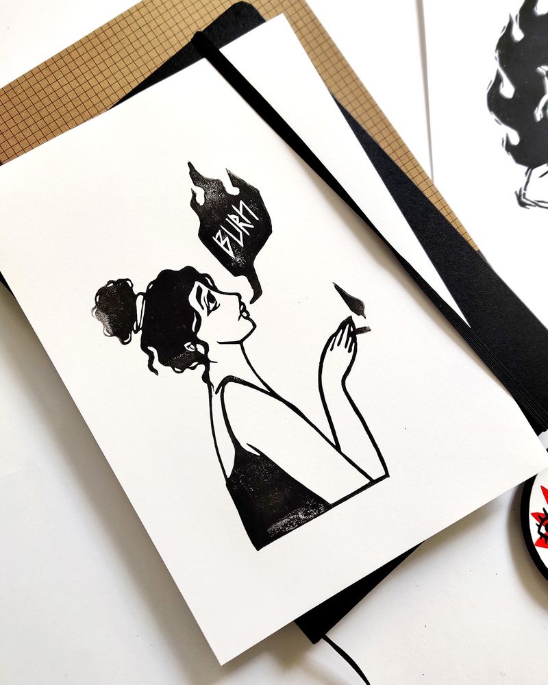 Photo d’une gravure représentant une femme de profil avec une queue de cheval haute et des cheveux ondulés, en train de fumer une cigarette. La fumée qu’elle expire ressemble à une bulle dans laquelle on peut lire le mot “burn”.
