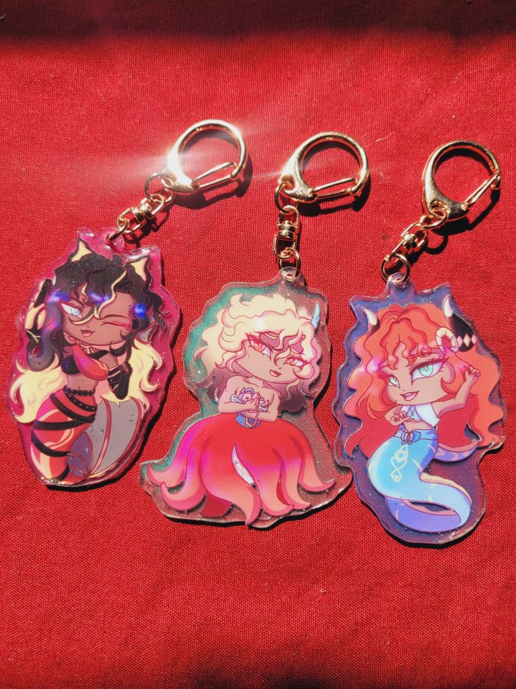 A keychain of kaveh, nilou, ans Dehya from Genshin Impact 