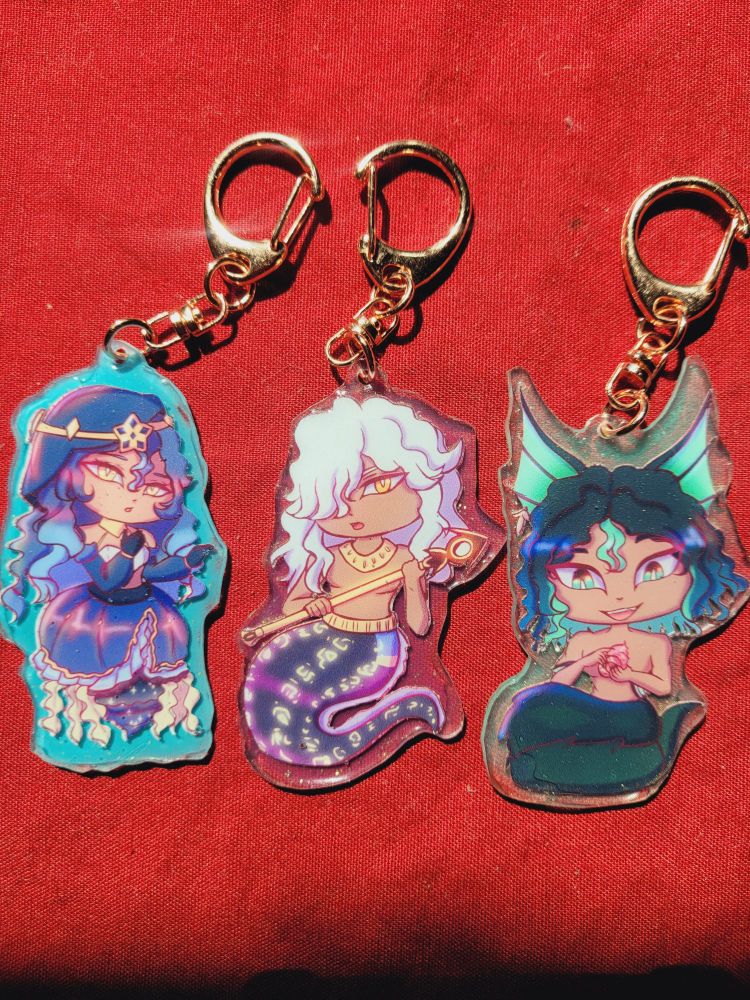 A keychain of Leyla, cyno, and Tighnari from Genshin Impact 