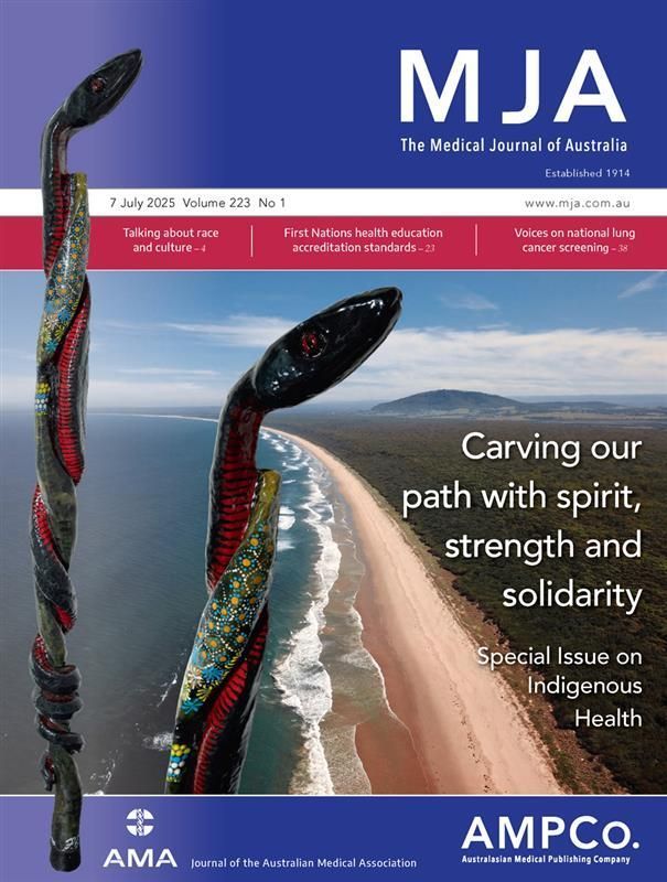 MJA cover with  The Red Belly Black Snake Walking Stick, a powerful carving by Uncle Paul Scott