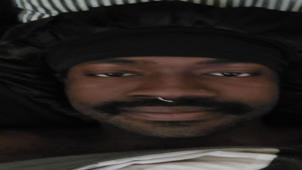 a picture of me from the neck up where a blanket over my chest, a bonnet on my head. and being an absolute cutey patootie while boasting a neutral face