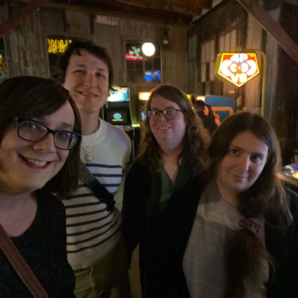 Lila, Claire, Jess, and Mira in front of pinball machines 