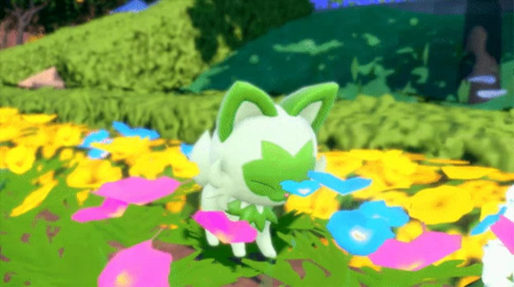 a white cat with green ears is standing in a field of flowers .