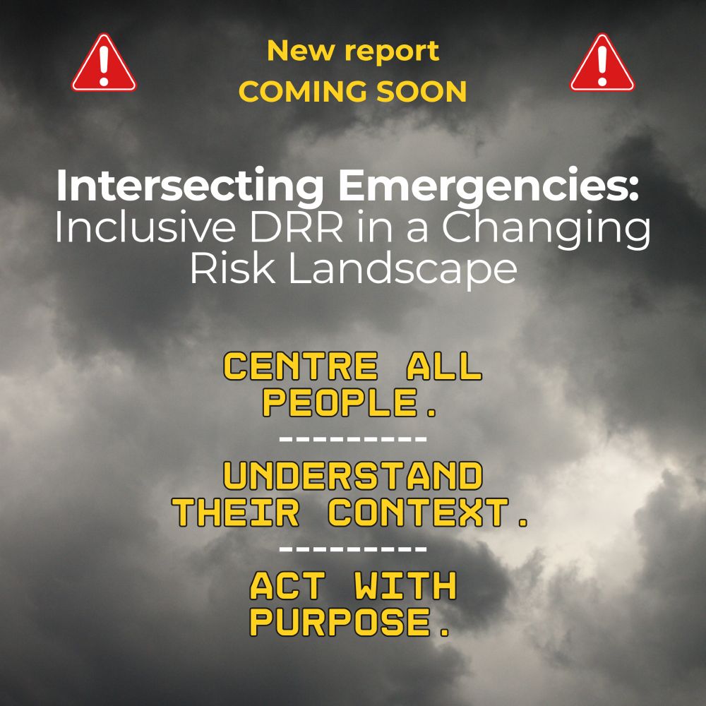 A dark, cloudy sky forms the background. At the top, yellow text reads “New report coming soon” with red warning icons on either side. In the centre, white text reads “Intersecting Emergencies: Inclusive DRR in a Changing Risk Landscape”. Below, bold yellow text in three lines reads: “Centre all people. Understand their context. Act with purpose.”