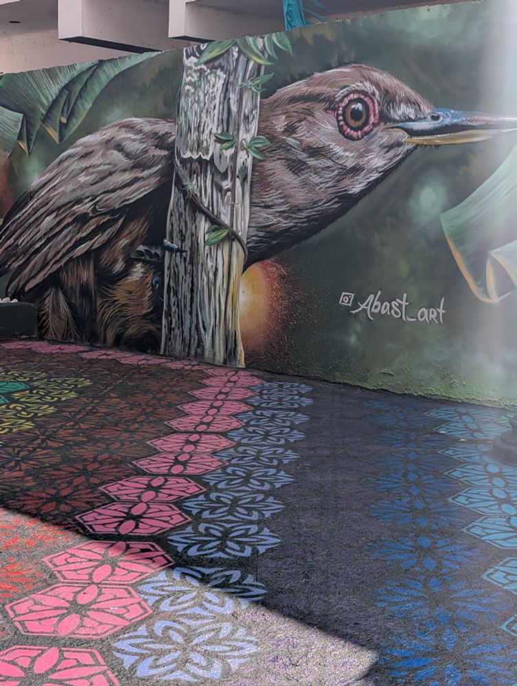 A mural of a bird with a multicolored tile floor
