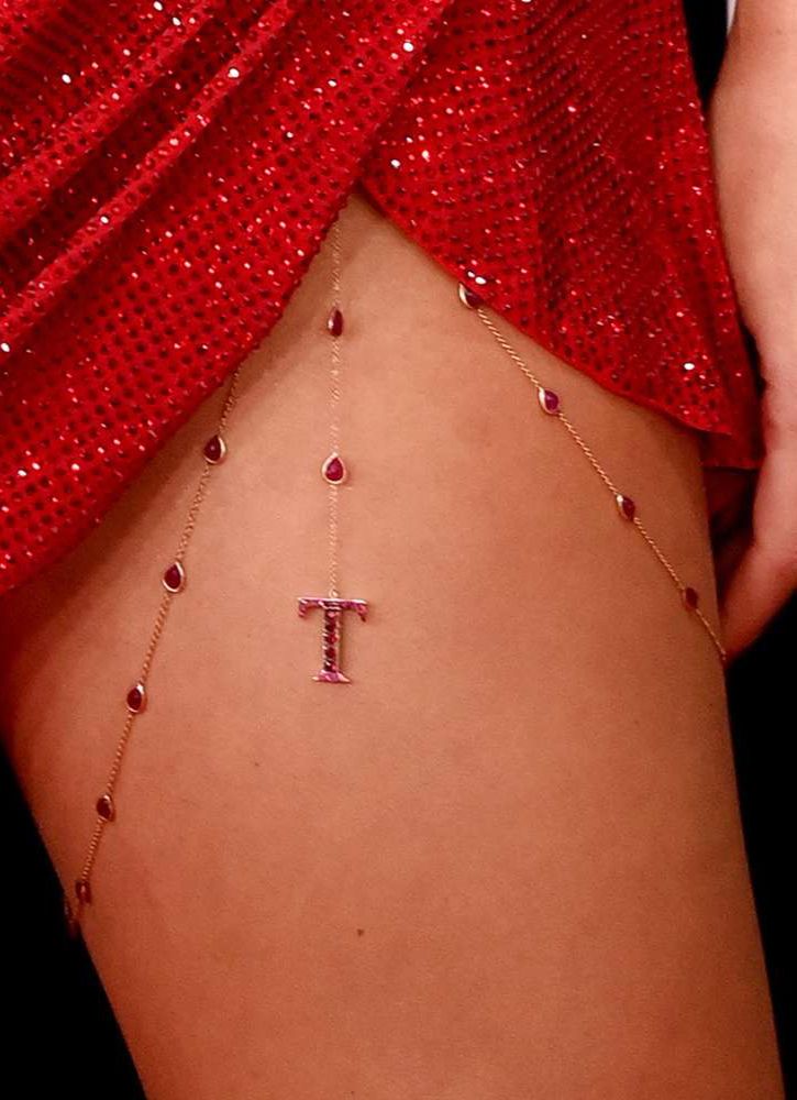 Taylor Swift’s thigh with a chain around it with a red ‘T’ dangling