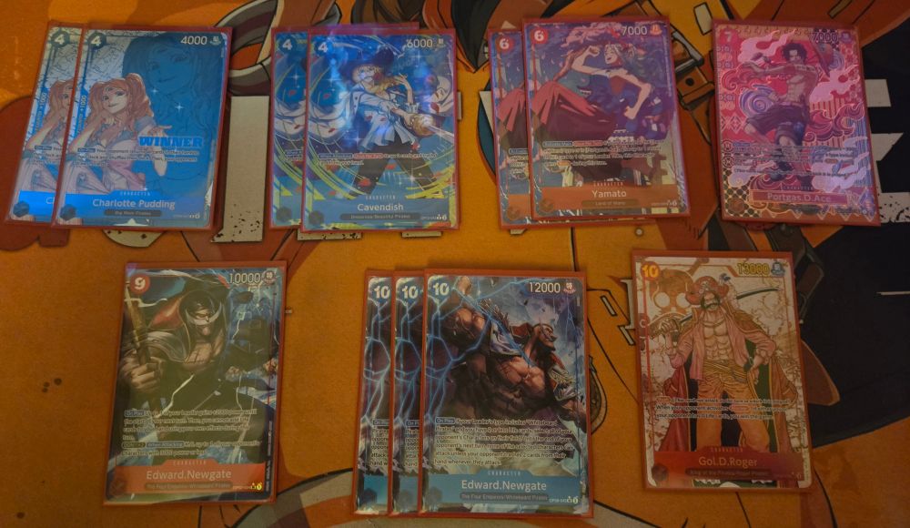 Photo of some alt arts for the one piece tcg including 2 winner 4c blue puddings, 2 rc cavendishes, 2 6c red yamatos, 1 7c red ace sp, 1 9c red newgate from prb, 3 10c blue "tax" newgates, and 1 10c red gol.d.roger