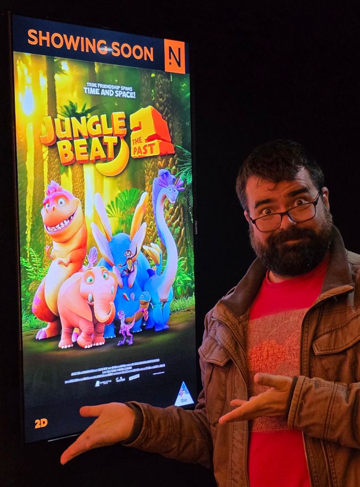 Sam Wilson standing in front of a poster for Jungle Beat 2 The Past