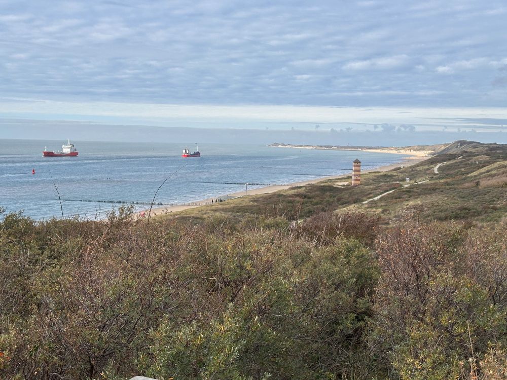 Dune coast. Some ships and lighthouses; one close, one very distant.
